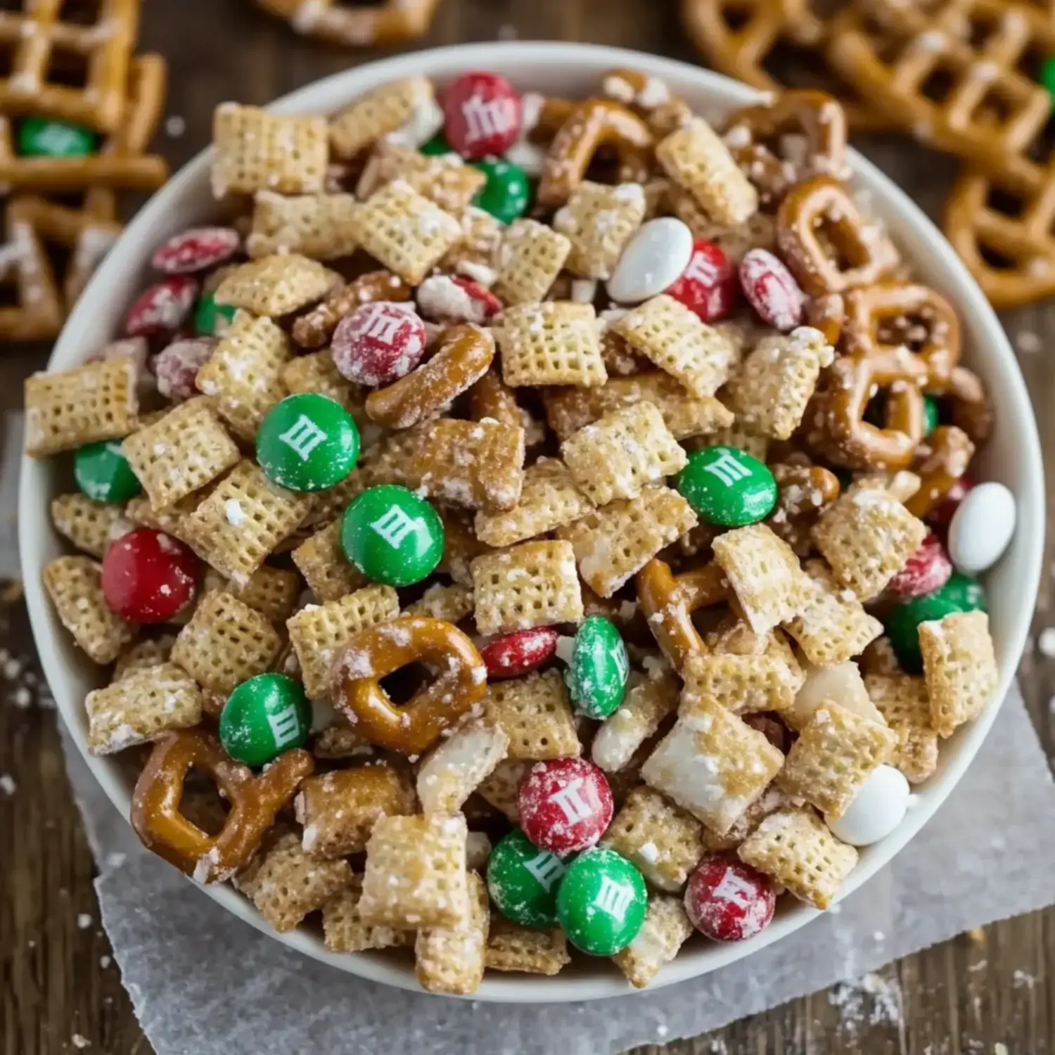 A colorful mix of pretzels, cereals, and M&Ms in a festive bowl.