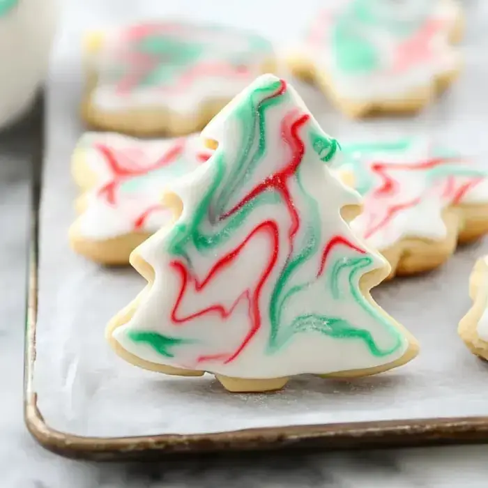 A festive tree-shaped sugar cookie with green and red marbled icing.