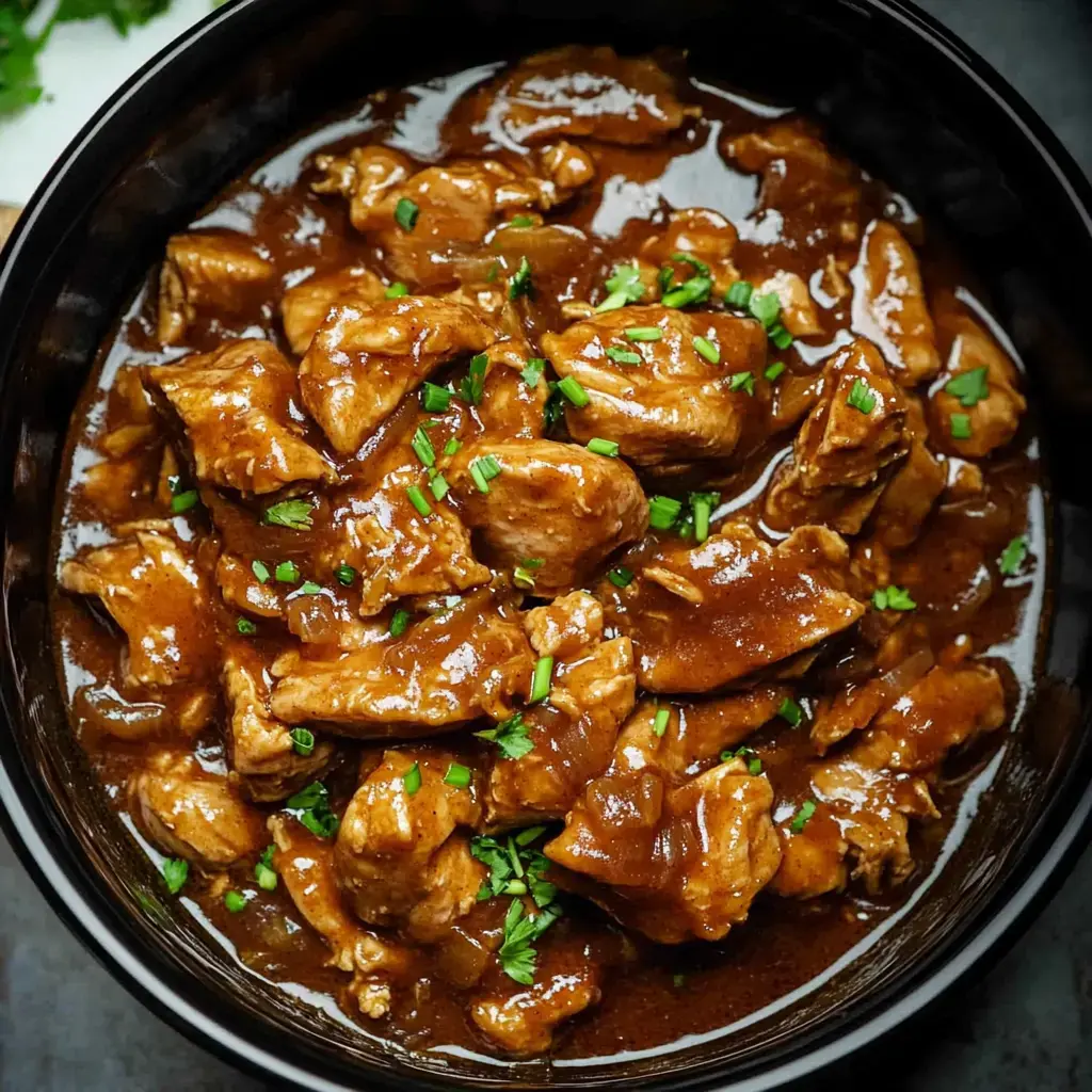 Bite-sized, juicy chicken pieces glazed in a rich, dark sauce and sprinkled with fresh herbs.