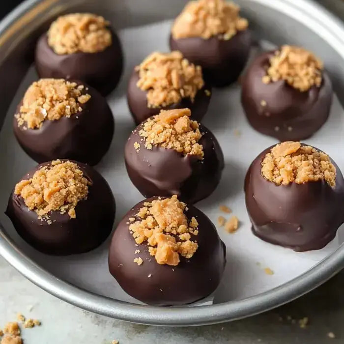 A silver tray packs chocolatey truffles that are sprinkled with crushed candy bits.