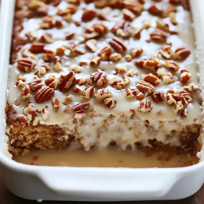 Super close look at a creamy, pecan-topped dessert in a baking pan.