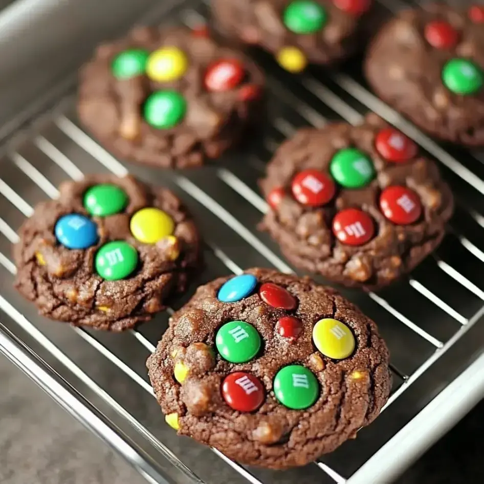 A batch of fresh chocolate cookies with bright candy shells on a tray.