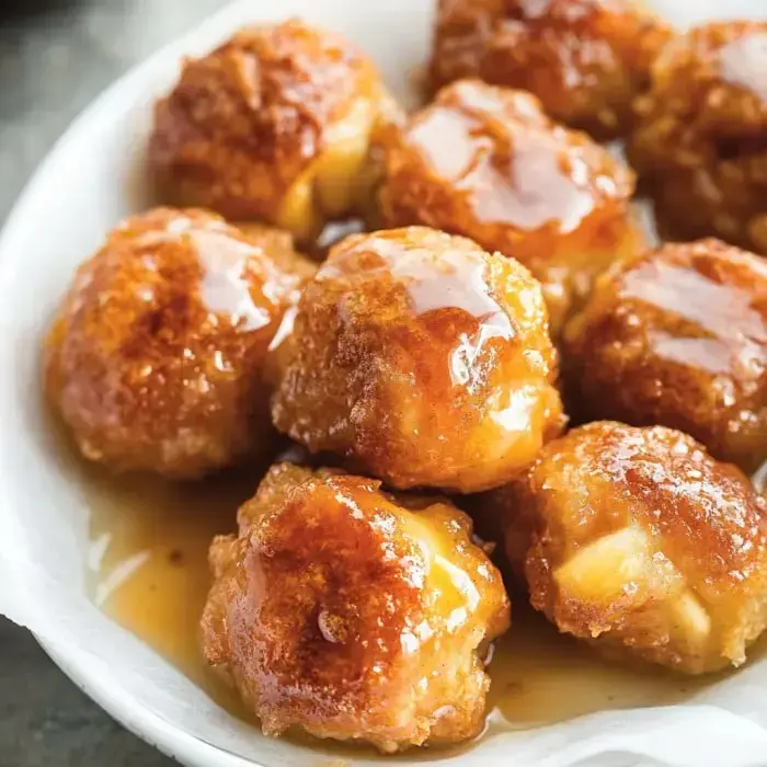 A plate packed with crispy golden snacks covered in sticky, sweet glaze.