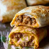 Golden-brown, cheesy tortilla pockets with spicy meat, on parchment paper.