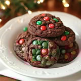 Plate of soft chocolate cookies decorated with red and green M&Ms, perfect for festive celebrations.