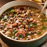 A flavorful bowl of smoky black-eyed peas, bacon, and greens in a rich broth.