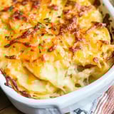 Close view of creamy cheesy potato bake with golden topping and parsley garnish.