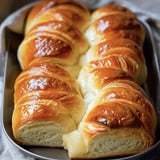 Golden and fluffy brioche-style rolls beautifully arranged on a platter.