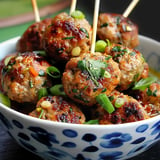 Golden meatballs garnished with green onions and coriander, served in a decorative bowl.